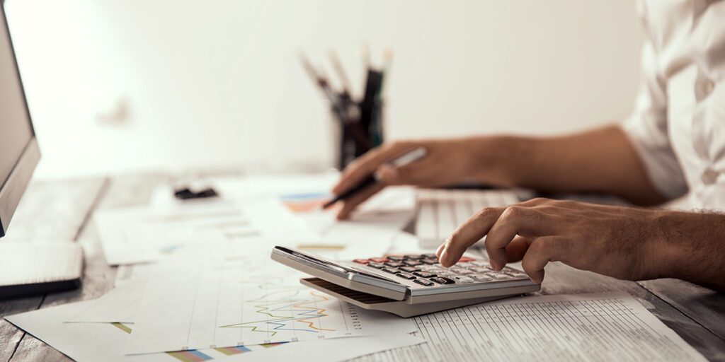 homme travaillant sur son bureau avec une calculatrice